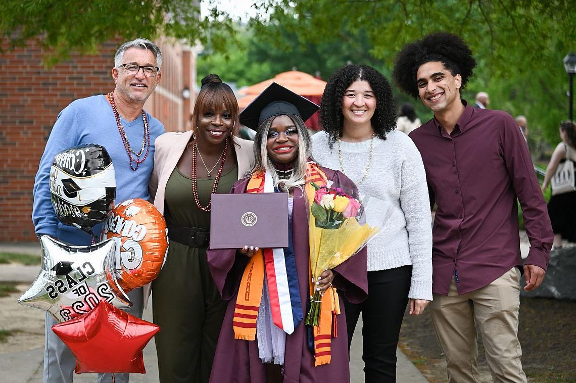 Image of a 2023 graduate and their four guests after Commencement.